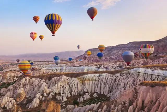 Turkey Cappadocia Balloons – Budget Holiday Hot air balloons flying over Cappadocia in Türkiye, a popular pick among the top cheap places to travel.